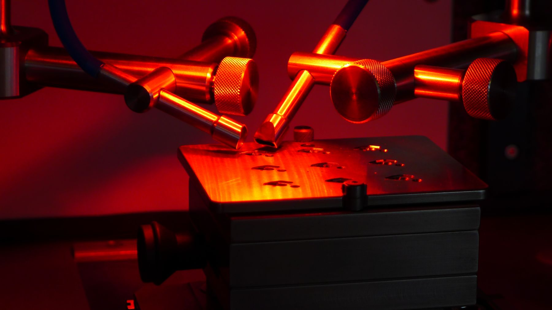 Machine laser UNIMEC en fonctionnement, faisceau et lumière rouge sur la pièce